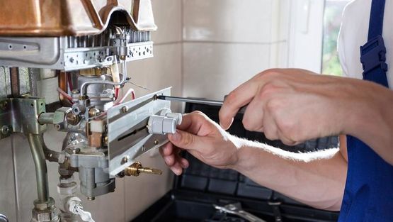 A plumber working on pipes in a domestic home